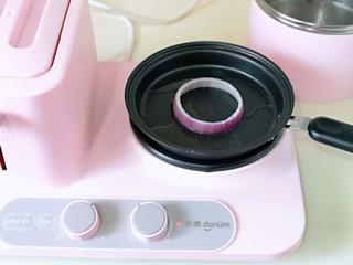 8、洋葱圈鸡蛋肉糜饼,煎锅中加入食用油,放上洋葱圈。