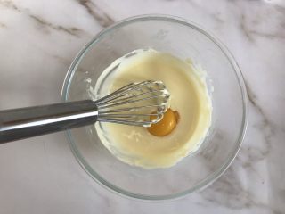 4、轻乳酪芝士蛋糕,稍冷却后分两次加入两个蛋黄搅拌均匀