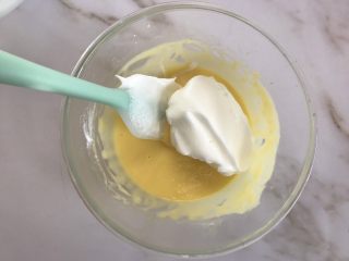 10、轻乳酪芝士蛋糕,取三分之一蛋白糊放入芝士糊中翻拌均匀