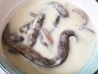 2、酥炸小鲶鱼,淀粉和面粉放入容器中添加适量清水搅拌成面糊将腌制好的小鲶鱼放入面糊中均匀的裹上面糊