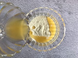 4、香橙溶豆,把橙汁倒入奶粉中
