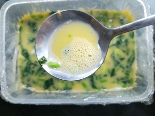 8、菠菜鸡蛋糕,准备一个保鲜盒或者适合的容器。铺上保鲜膜，不铺保鲜膜内壁刷油也可以。把鸡蛋液倒进去，撇去浮沫。