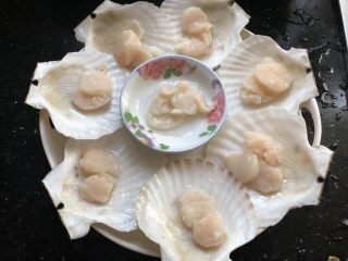 2、粉丝蒸扇贝,总刀把扇贝破开，沿着壳壁小心的取下贝肉，去掉内脏和腮，留下壳肉和月牙形的黄（我们家不喜欢，我全给扔掉了），把贝肉分到贝壳上。