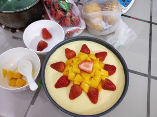 13、免烤箱零失败 芒果慕斯蛋糕,先把水果切好，芒果切粒，草莓对半切开，然后再将冷藏好的慕斯蛋糕取出，此时的蛋糕已经成型，轻轻的将水果铺在蛋糕表面，按个人喜好摆好造型，脱模的时候用吹风机热风围着蛋糕均匀受热吹几圈就能轻松脱模啦！（这个步骤忘记拍了，实在不会可以百度）