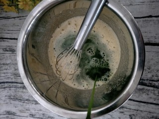 9、宝宝辅食 超萌甜甜圈,把菠菜汁加入到搅拌好的蛋糊里。