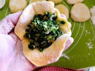 21、黄金菜团子,取一个面皮，在面皮上放入一勺馅料，包成包子