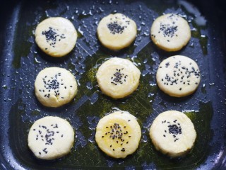 9、平底锅版奶香土豆饼,表面撒上黑芝麻，慢火煎至两面金黄时，即可出锅摆盘。