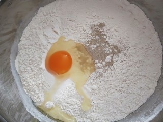 5、黄金南瓜小馒头,加入面粉，酵母，打入鸡蛋，把蒸好的南瓜倒入面粉里直接合成面团。