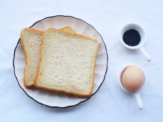 1、超好吃的土司条,准备材料:土司2片,鸡蛋1个,黑芝麻适量。