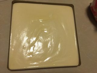 9、肉松小贝,将蛋糕糊倒入不粘烤盘中，将烤盘举起距离案面10cm处震泡2次