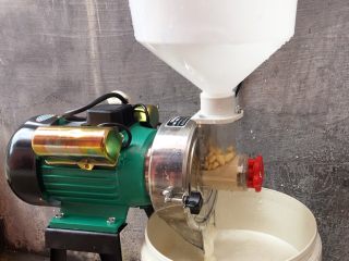 3、纯手工豆腐皮,将泡好的黄豆放入磨豆机中打磨,边加黄豆边添水,磨的越细腻越好。