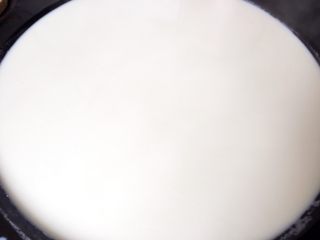 8、纯手工豆腐皮,浮泡一定要撇的干干净净的。然后上火,刚开始可以多添点柴,因为这时候豆浆是冷的,等这豆浆慢慢热起来就要慢慢添加柴火了。做豆腐皮火候是最关键的,火太小,豆腐皮容易化;火太大,豆腐皮容易滚破。