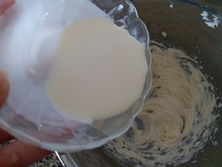 4、巧克力豆曲奇,把淡奶油分三次加入到黄油里,用电动打蛋器打发黄油。