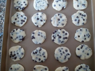 9、巧克力豆曲奇,沾满巧克力豆的面团,用她的小手按扁后,放进烤盘里。