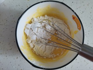 4、舒芙蕾蛋糕,筛入低筋面粉画“z”字翻拌均匀至无干粉颗粒