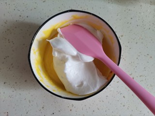 11、舒芙蕾蛋糕,取1/3蛋白霜到蛋黄糊里从下至上翻拌均匀，注意手法不能画圈搅拌，会消泡