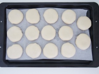 13、玫瑰酥饼,烤盘上铺上油纸，将做好的玫瑰饼摆放在烤盘上，轻轻压扁。