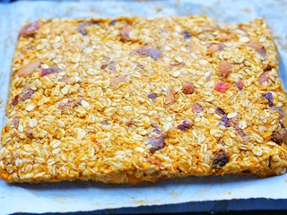 9、冬至美食 南瓜燕麦块,将南瓜糊放在烤盘整成长方形，压紧。