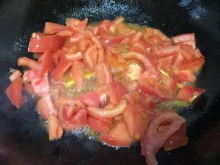 6、蛤蜊鸡蛋面疙瘩,锅里放入适量的油，爆香葱姜加入番茄翻炒片刻至番茄软烂