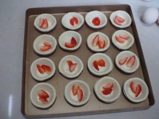5、草莓蛋挞,然后将蛋挞皮放入烤盘中,放入草莓