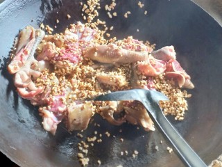 7、铁锅糊米鸡,把鸡肉放下去炒一下。