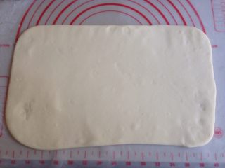 4、黑芝麻香葱花卷,发酵好的面团取出排气,在案板上撒些面粉,将面团擀成长方形