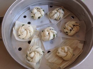 12、黑芝麻香葱花卷,放在蒸笼里,花卷坯子下面可以垫油纸或者玉米垫。室温低,在蒸锅里放热水,将蒸笼放上,醒发15-20分钟