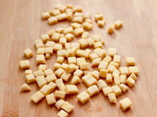 8、奶香小花朵馒头,把边角料重新揉匀后，再次擀成薄片后，用刀切成小豆豆，也可以继续用模具压成小花朵。