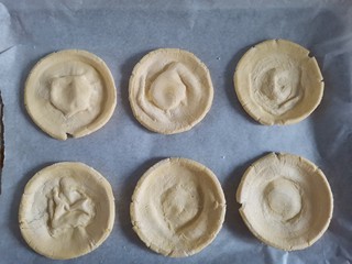 4、草莓拿破仑小蛋糕（蛋挞皮版）,他皮提前拿出来解冻，解冻之后撕掉锡纸，把蛋挞皮压成饼状