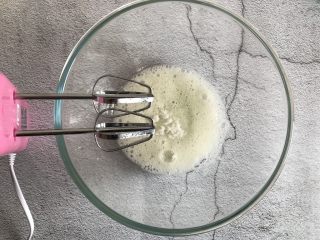 6、草莓抱抱卷,蛋清用电动打蛋器打至鱼眼泡加入三分之一的白砂糖