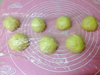 3、芝士肠仔包,一次发酵好的面团均分成6-8份，盖上保鲜膜松弛15分钟。