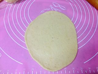 4、芝士肠仔包,取一个小面团擀成与纸模同宽的椭圆形薄面片。