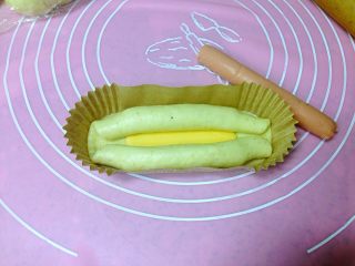7、芝士肠仔包,把面卷放入纸模，中间微微撑开。