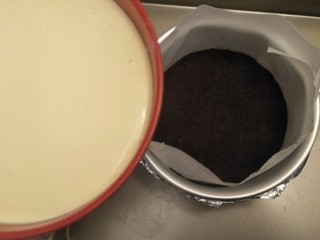 15、纽约芝士蛋糕,把奶酪糊倒入模具中，我们这里是普通戚风模具，所以垫了油纸防粘，如果用不粘模具就不要垫油纸啦。