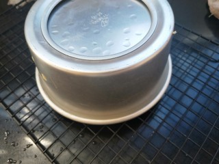 13、南瓜蒸蛋糕,关火，停顿一下，取出，迅速撕掉保鲜膜，倒扣在架子上。