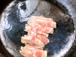 3、鲜活时蔬面,锅中添入适量清水下入肥牛片微煮变色