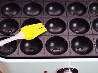 15、荠菜豆渣丸子,新思特多功能美食锅烧热后，用刷子蘸少许花生油，把模具涂抹均匀。