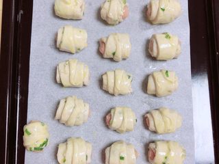 5、葱油飞饼香肠卷,肉卷表面刷一层薄薄的蛋黄液。提前预热烤箱，180度预热5分钟。