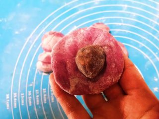 14、宝宝健康食谱 紫薯豆沙包,在面皮上放入一颗红豆沙