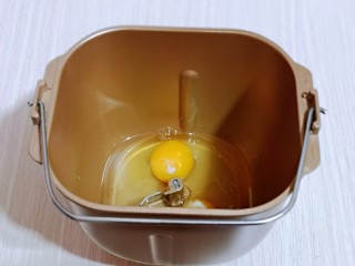 3、香甜松软的喜饼,首先将花生油与鸡蛋加入面包桶中。