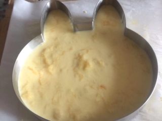 15、小熊维尼芒果慕斯蛋糕,冷藏好的慕斯底从冰箱取出，把慕斯糊先倒入一半进去^o^