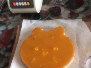 25、小熊维尼芒果慕斯蛋糕,脱模好后的慕斯，用果膏画维尼小熊的脸^o^