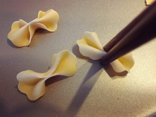 6、缤纷手工营养面-让宝贝快乐成长的健康辅食,上面是蝴蝶面的做法，先用模具压扣出造型，然后用筷子从中间夹一下