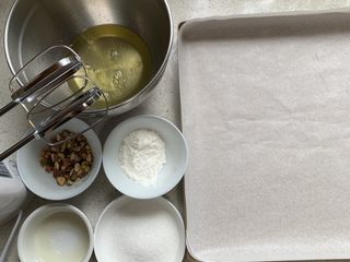 1、无油蛋白舒芙蕾,所有材料备好、烤盘垫油纸，坚果切碎，烤箱150度预热