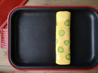 12、酷夏里的小清新——青瓜厚蛋烧,继续从左端卷起，卷起后再烘一下至蛋液完全凝固。