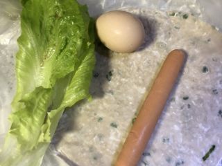 1、手抓饼,取食材，粮全其美葱香手抓饼1个，土鸡蛋1个，金锣火腿肠1根，生菜2片