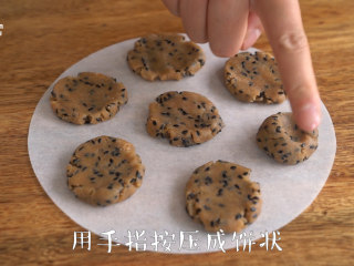 7、【全麦芝麻酥饼】口感更加香浓,将面团分成10g每个，搓成小圆球，放于烘焙纸上，压成小圆饼。