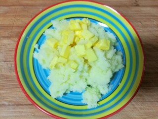 7、仿真蛋黄酥~宝宝辅食食谱,趁着土豆泥还是热乎的时候加入切好的黄油。