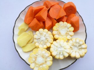 2、胡萝卜玉米排骨汤,胡萝卜去皮洗净切滚刀块,玉米去须洗净切断,姜去皮切片。