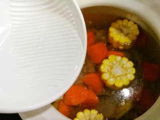 6、胡萝卜玉米排骨汤,加入料酒。